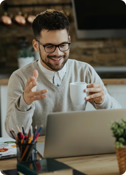 homem em frente ao computador segurando uma xicara de café